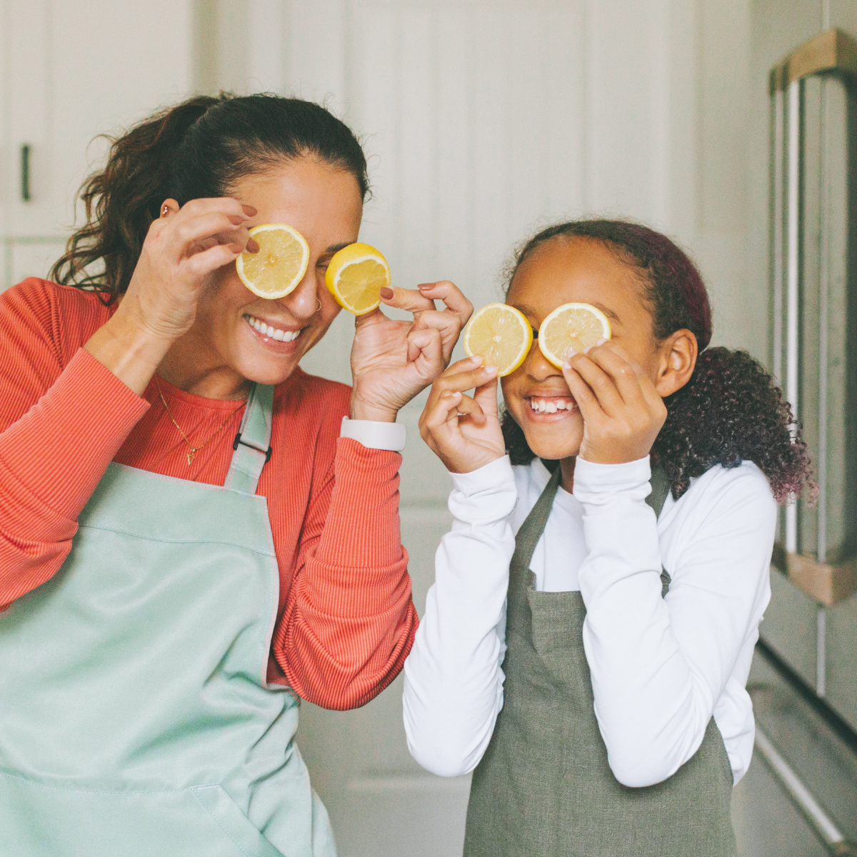 Summer Skip A Pay 2025 (1200 x 1200 px) (1) Mother and daughter holding up lemon slices in front of thier eyes.